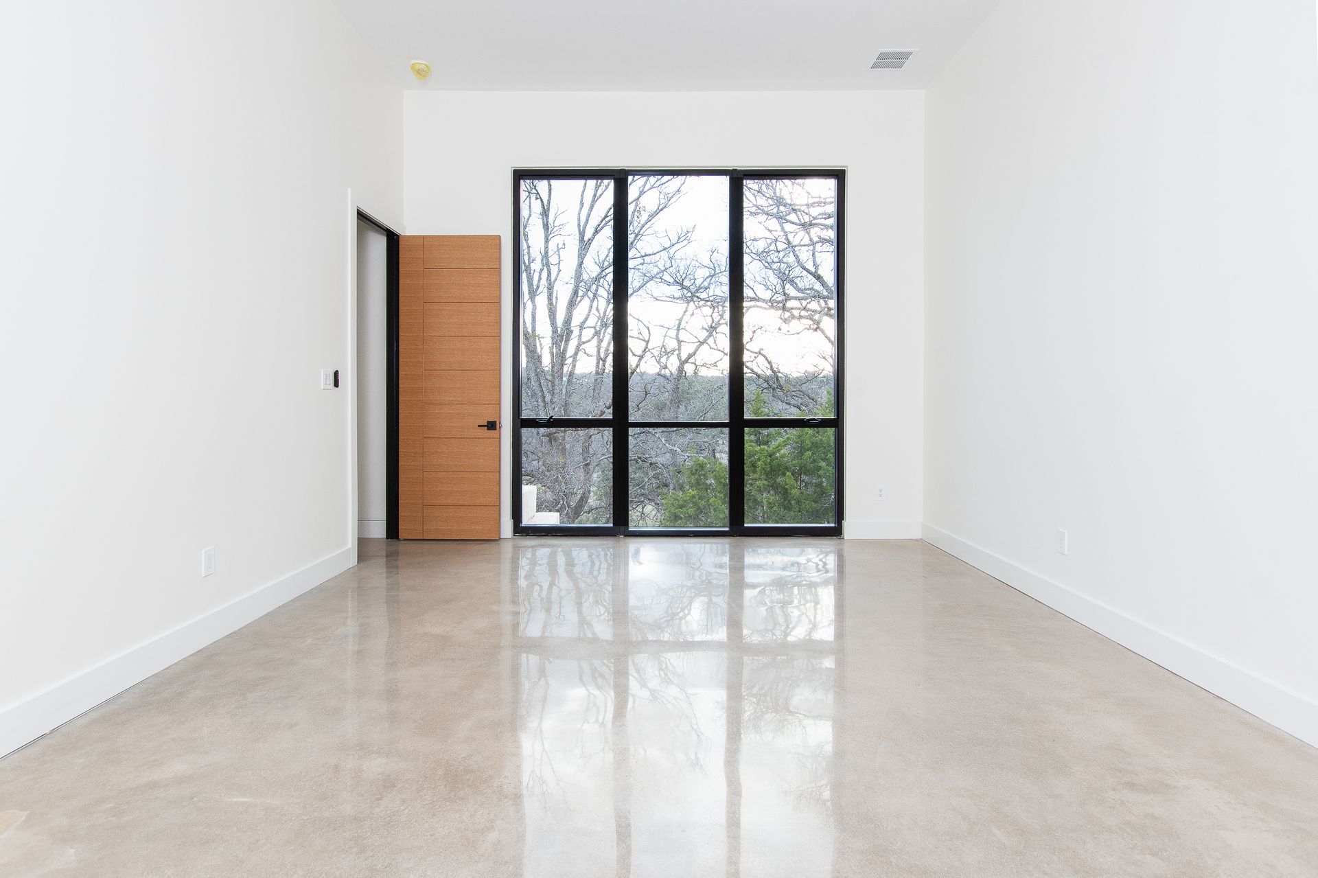 An empty room with a lot of windows and a door.