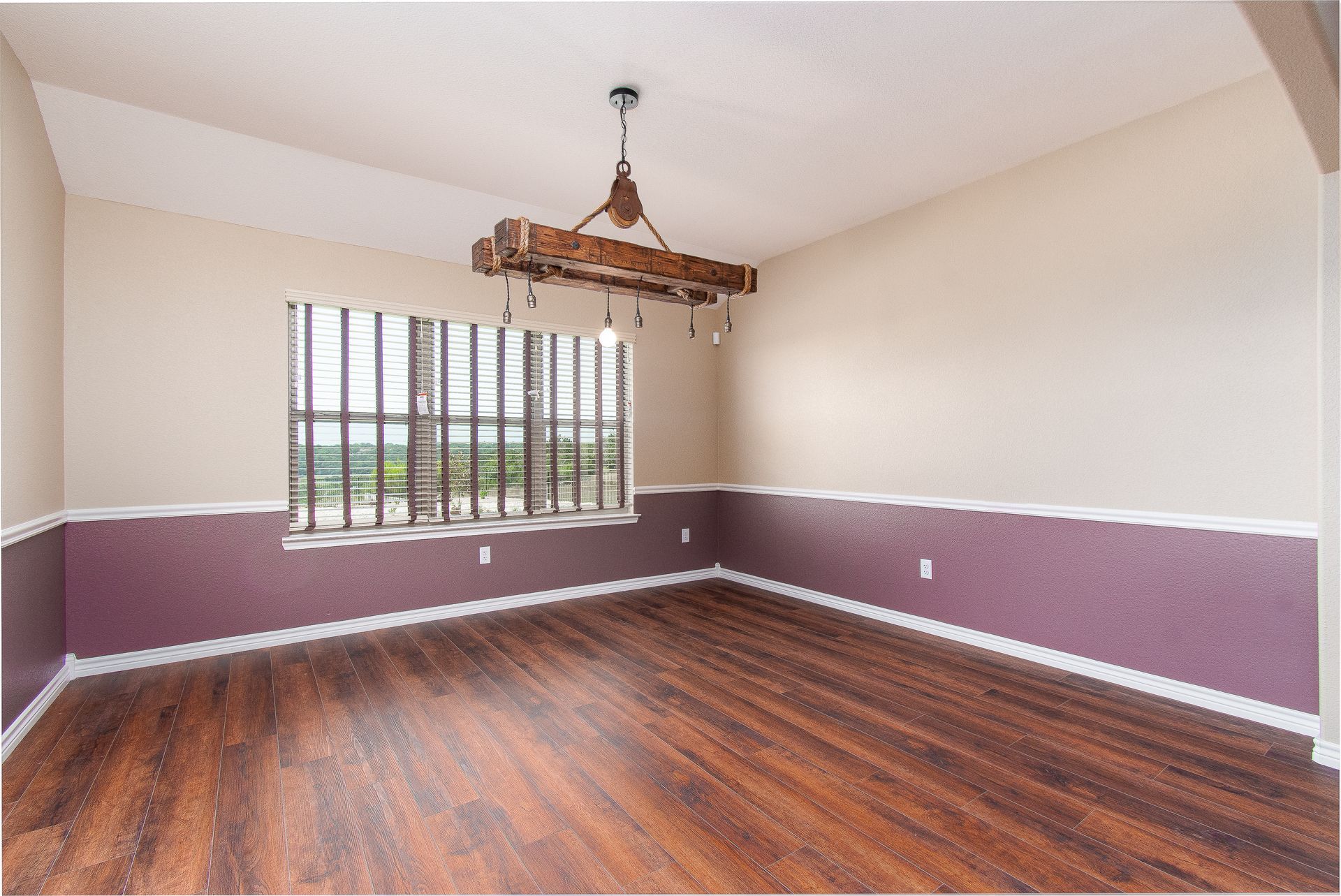 An empty room with purple walls and hardwood floors
