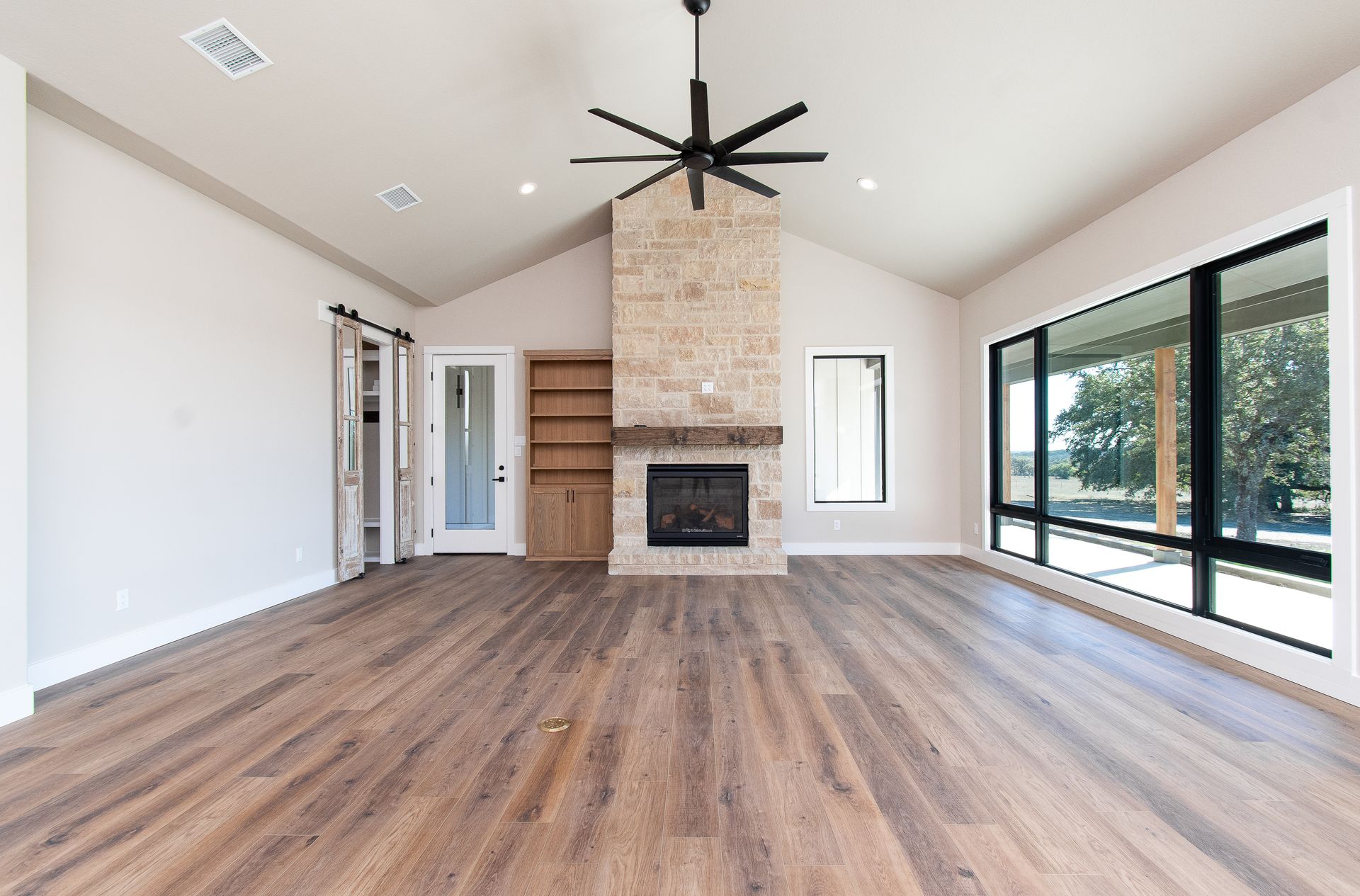 An empty living room with hardwood floors and a fireplace.