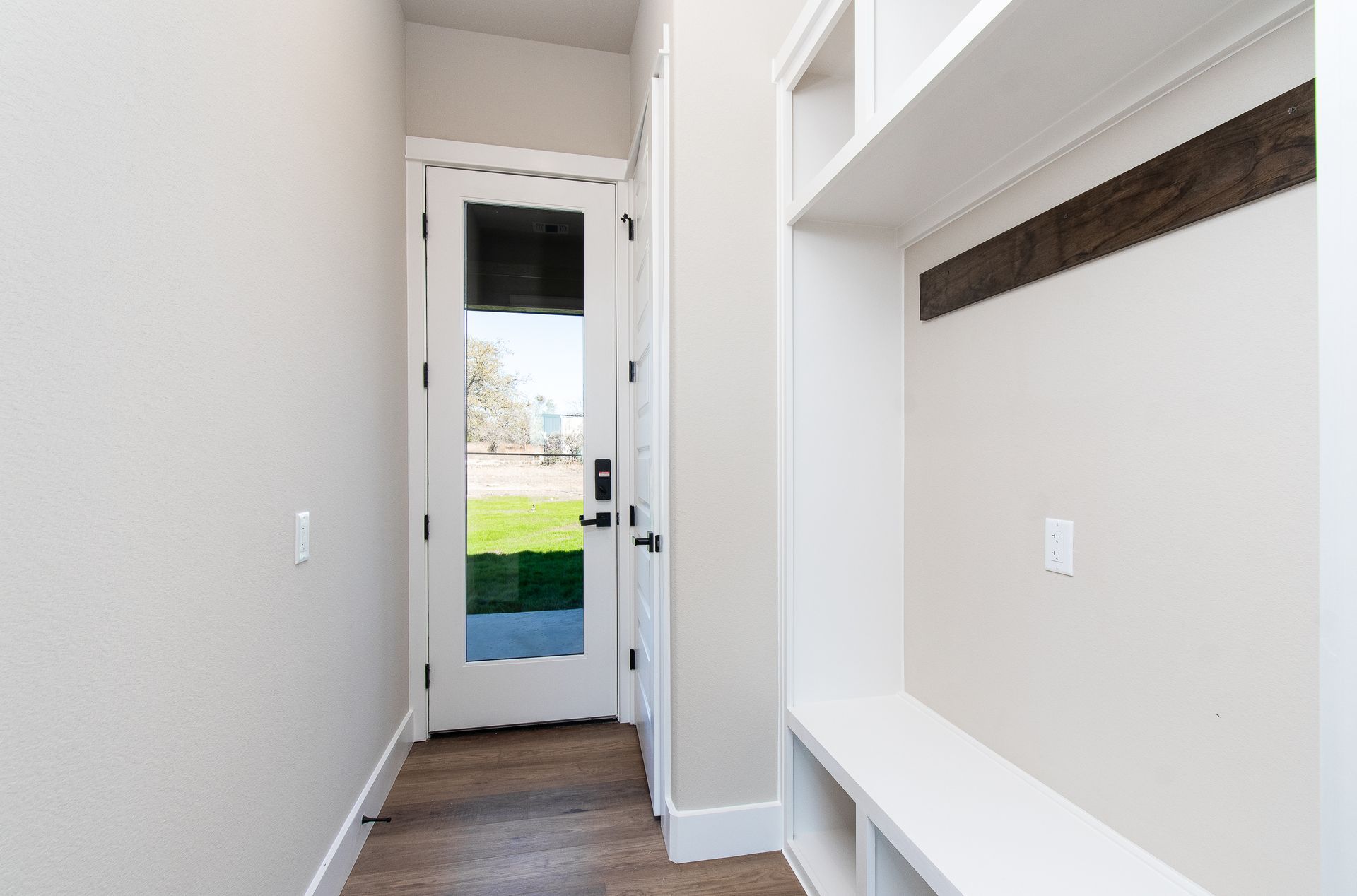 A hallway with a door and a bench in a house.