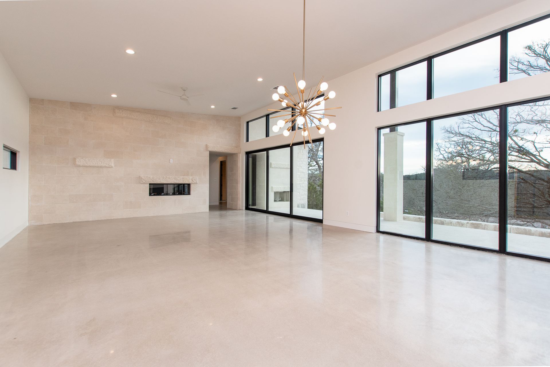 A large empty room with lots of windows and a chandelier.