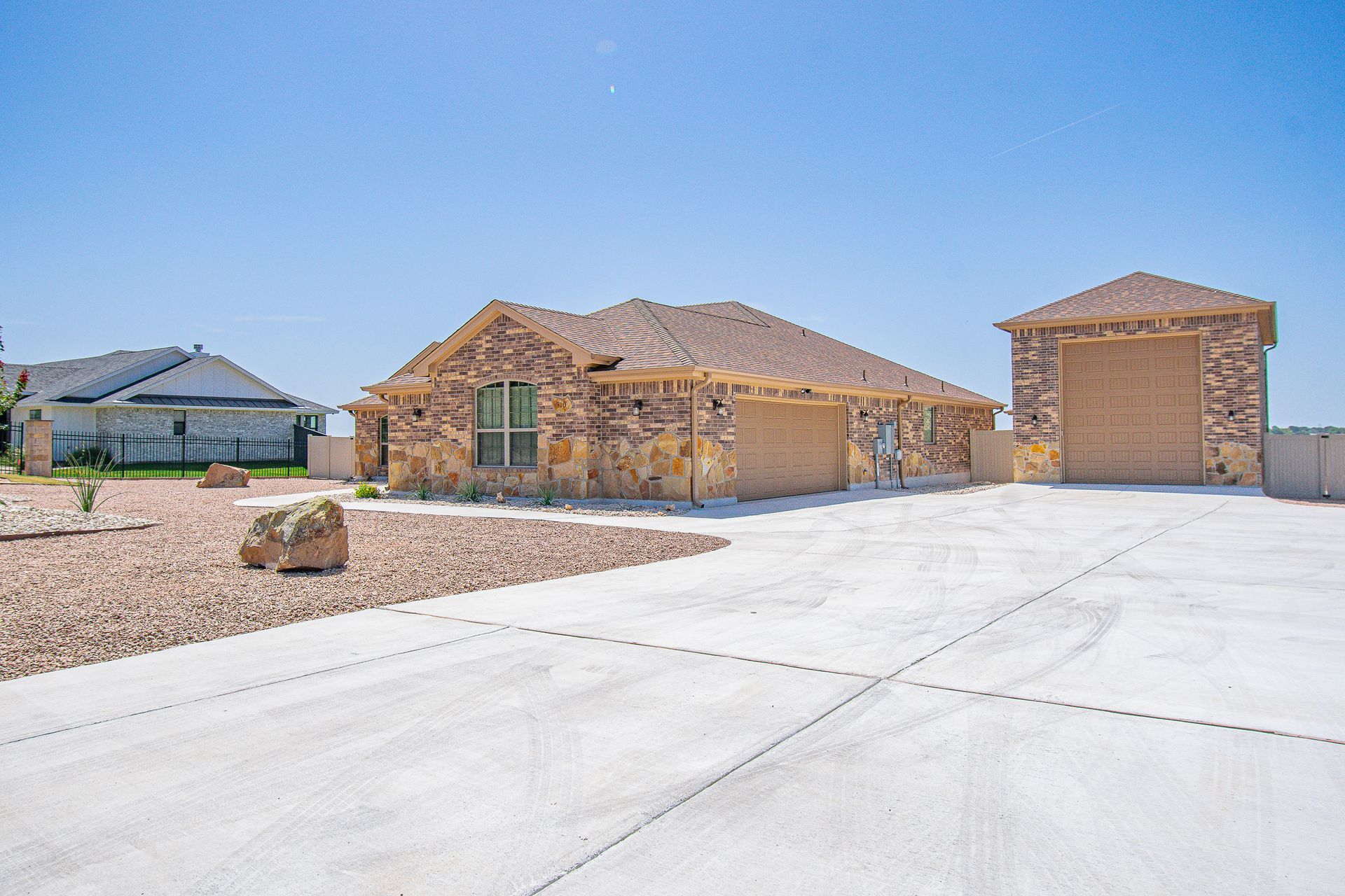 A house with a garage and a driveway in front of it.