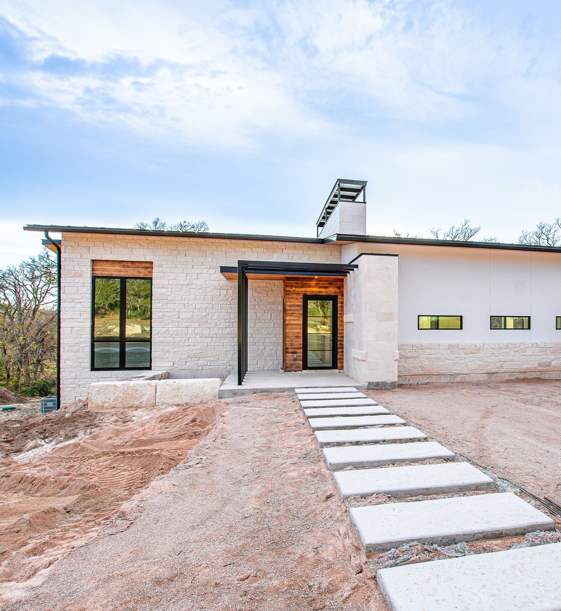 A white brick house with a walkway leading to it.