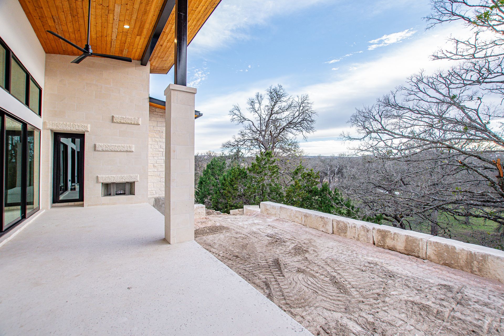 A large house with a patio and a view of a forest.