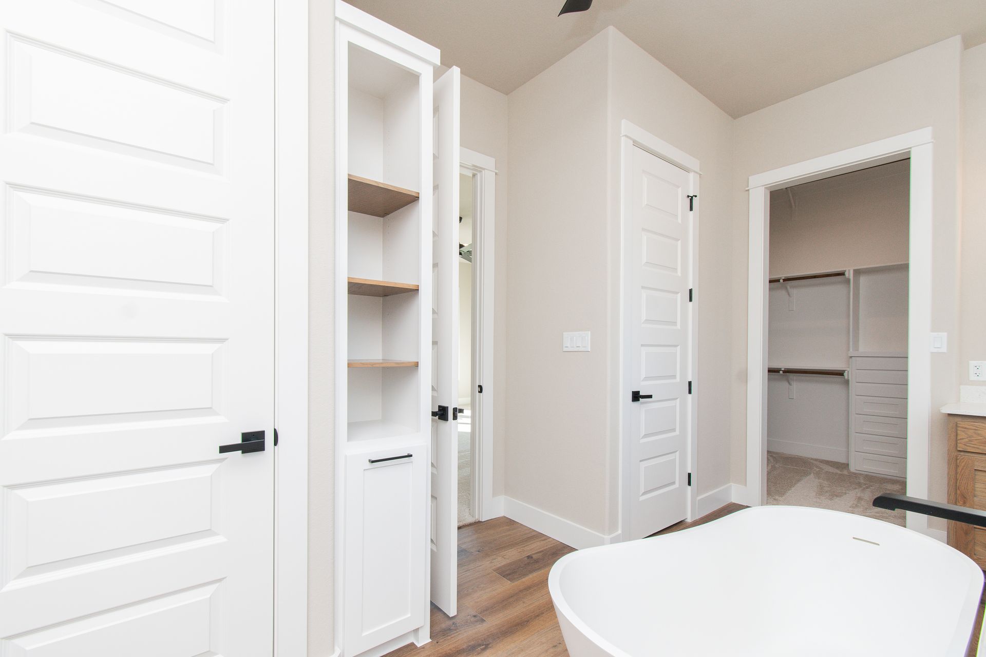 A bathroom with a bathtub , closet , and walk in closet.
