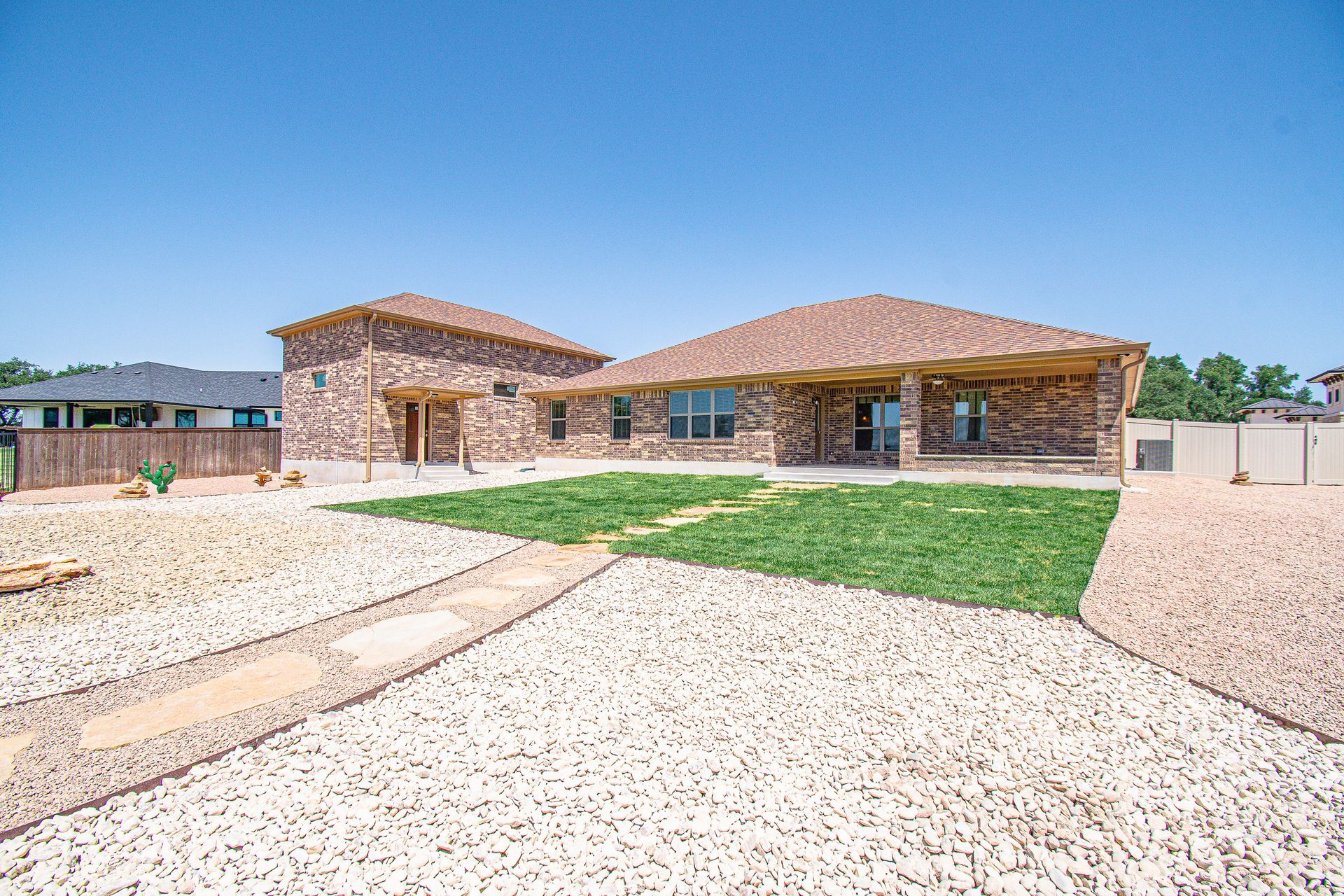 A large brick house with a large lawn in front of it.