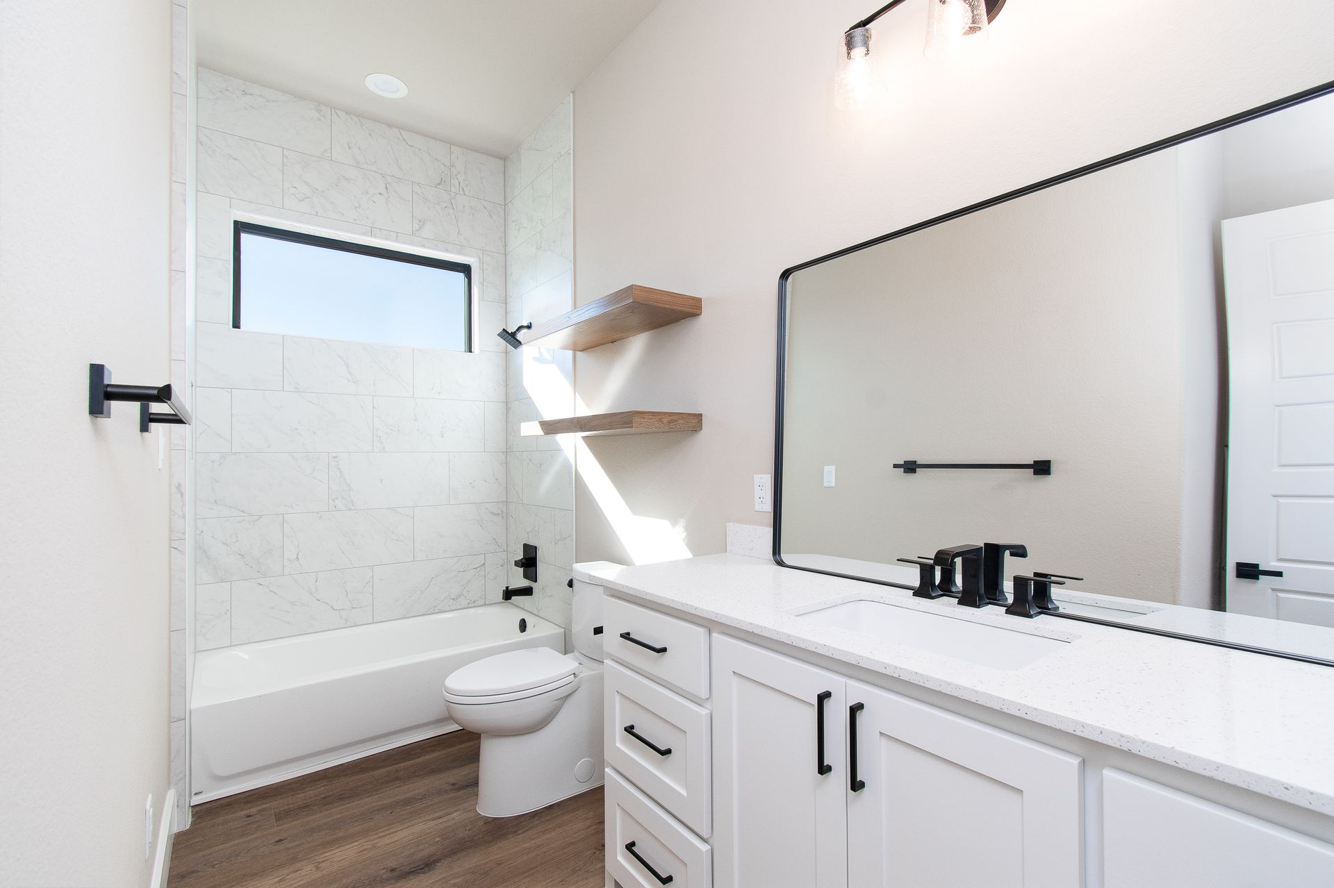 A bathroom with a toilet , sink , and mirror.