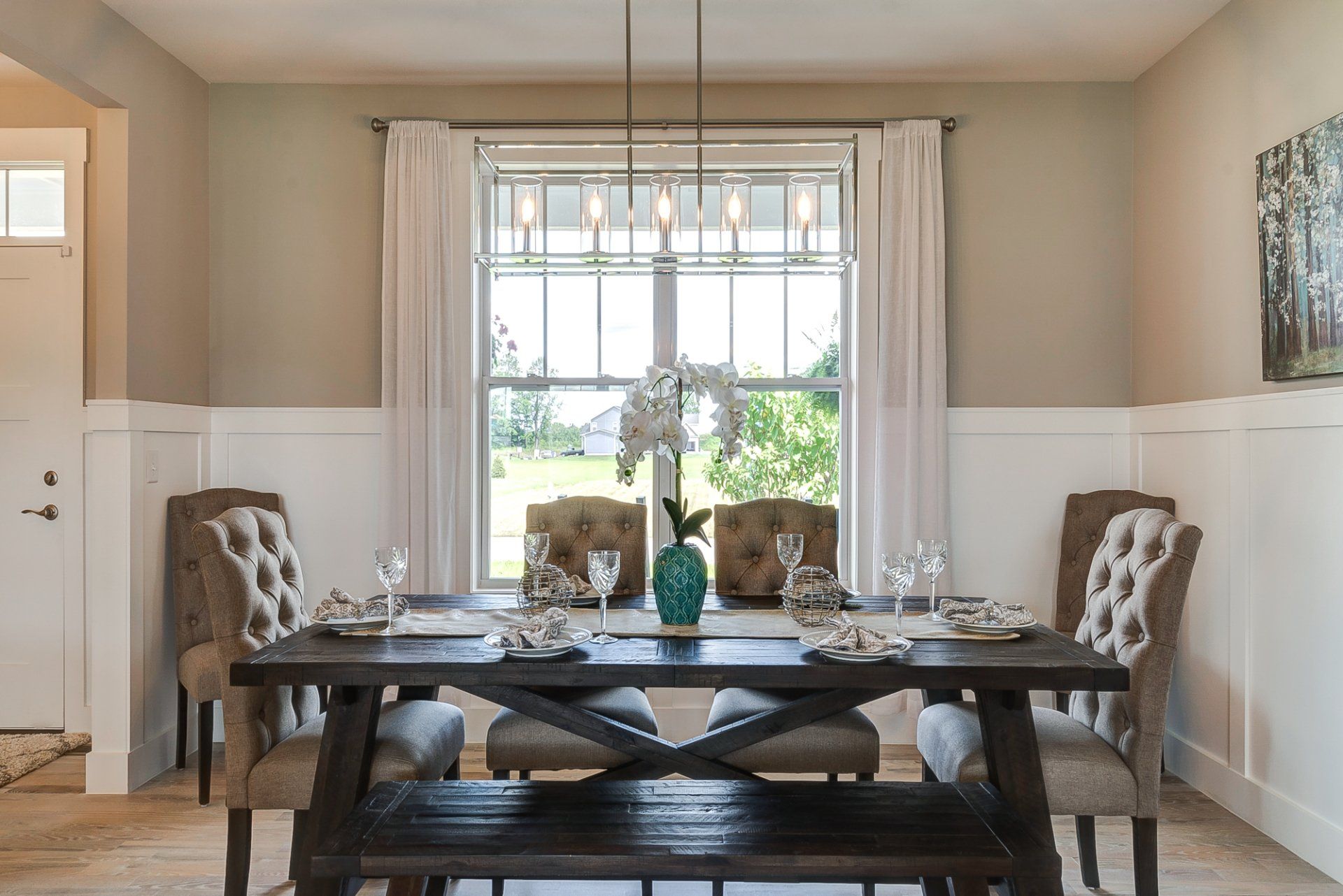 A dining room with a table and chairs and a bench.