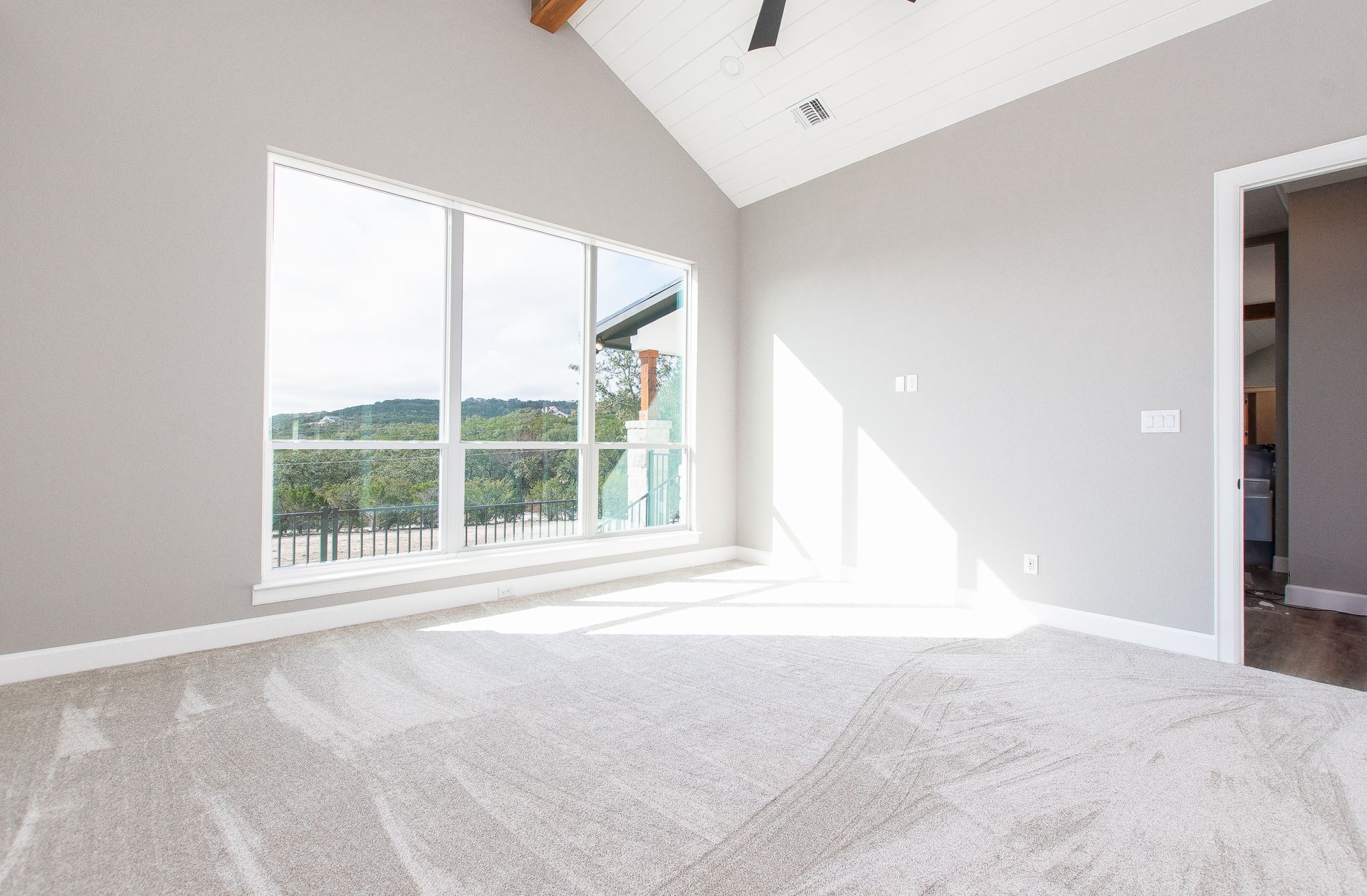 An empty room with a vaulted ceiling and a lot of windows.