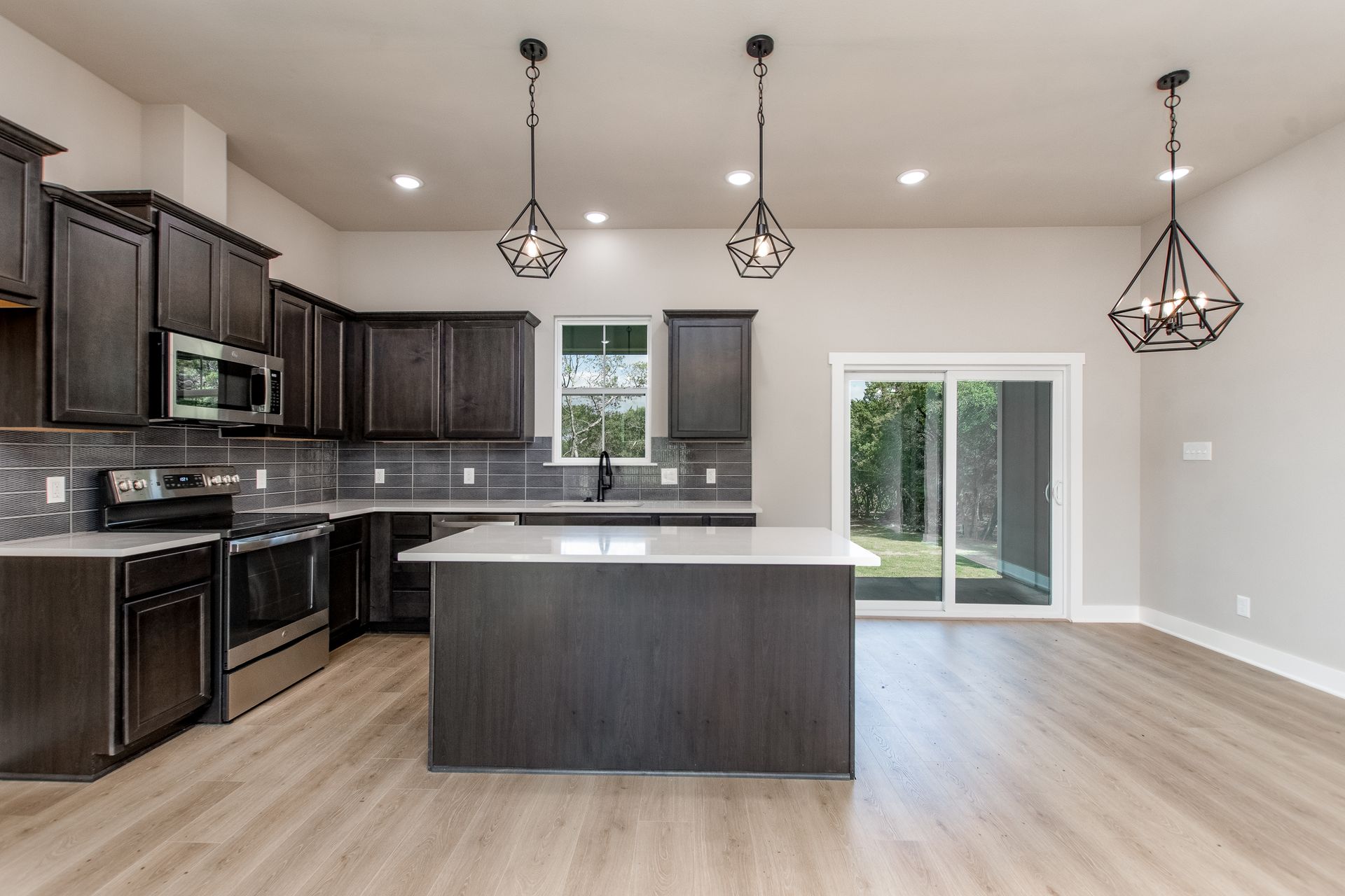 An empty kitchen with a large island in the middle of the room.