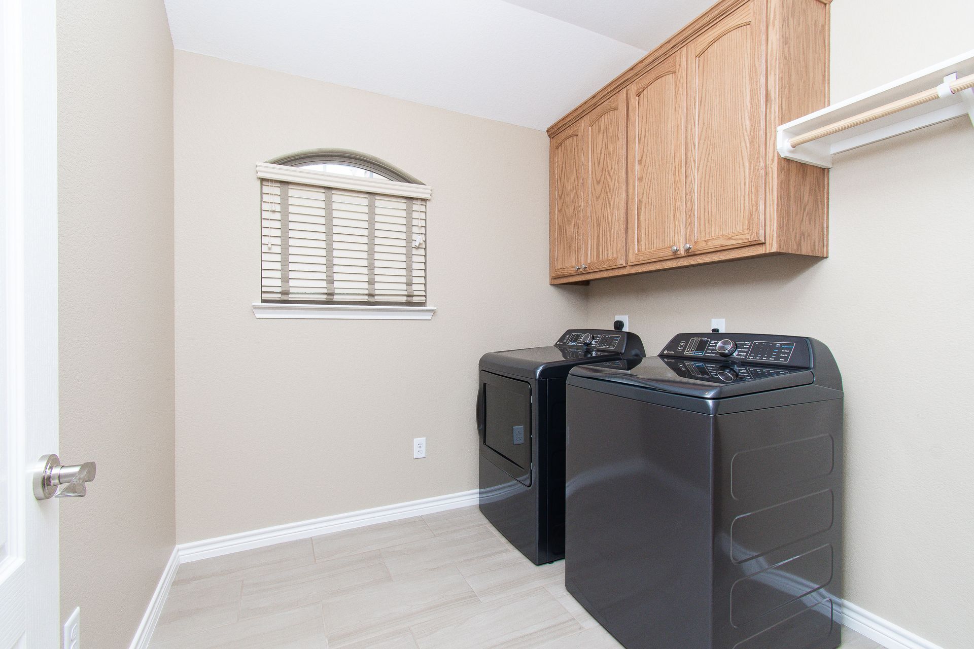 A laundry room with a washer and dryer and a window.