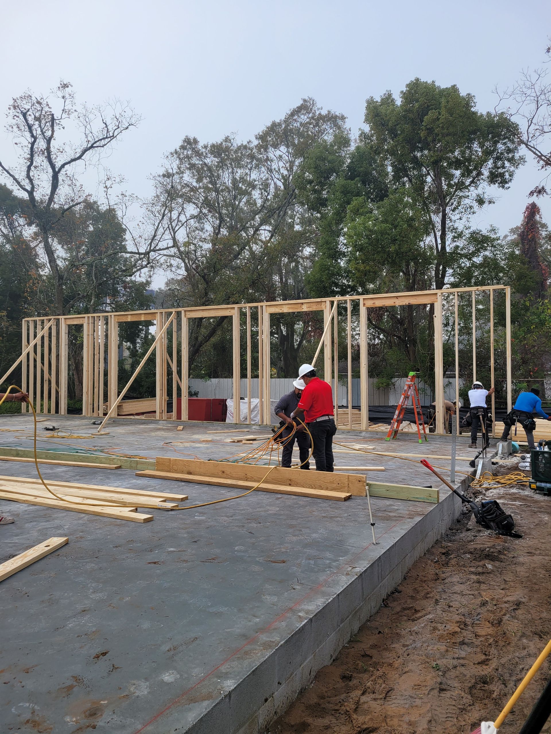 A group of construction workers are working on a house under construction.
