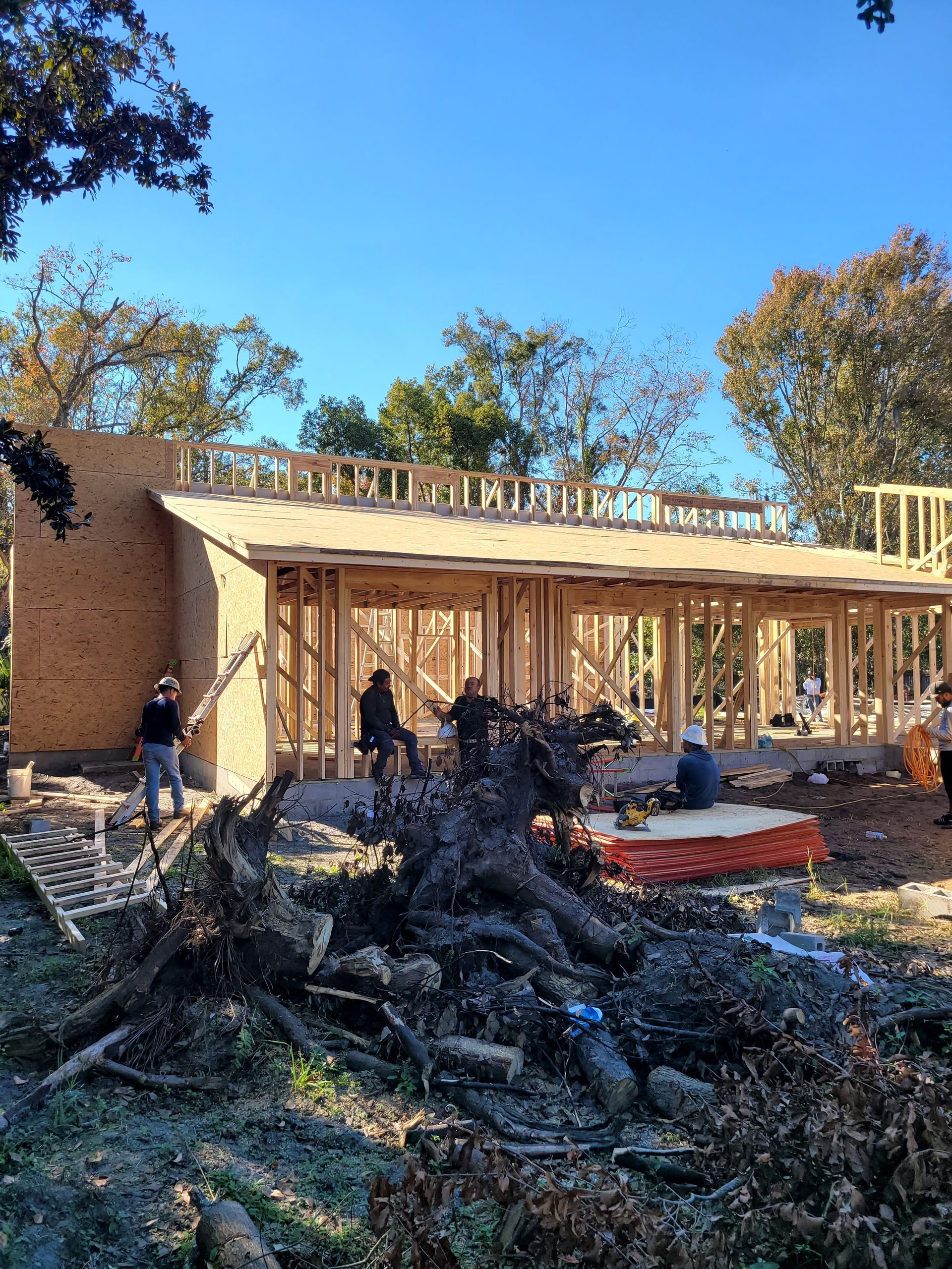 A house is being built with a lot of trees in the background.