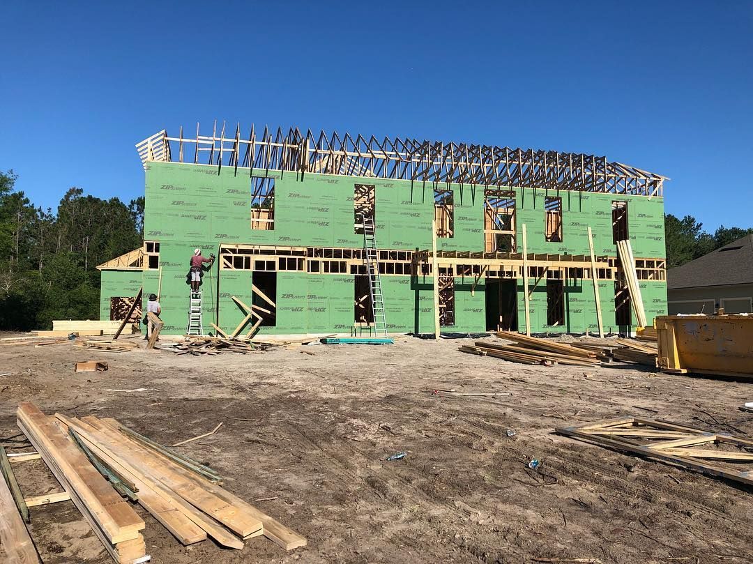 A large building is being built in a dirt field.