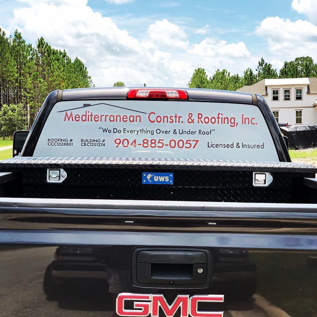 A swimming pool surrounded by palm trees and a fence