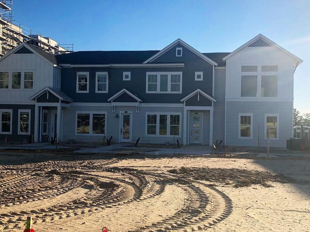 A large house with a lot of windows and a lot of dirt in front of it.