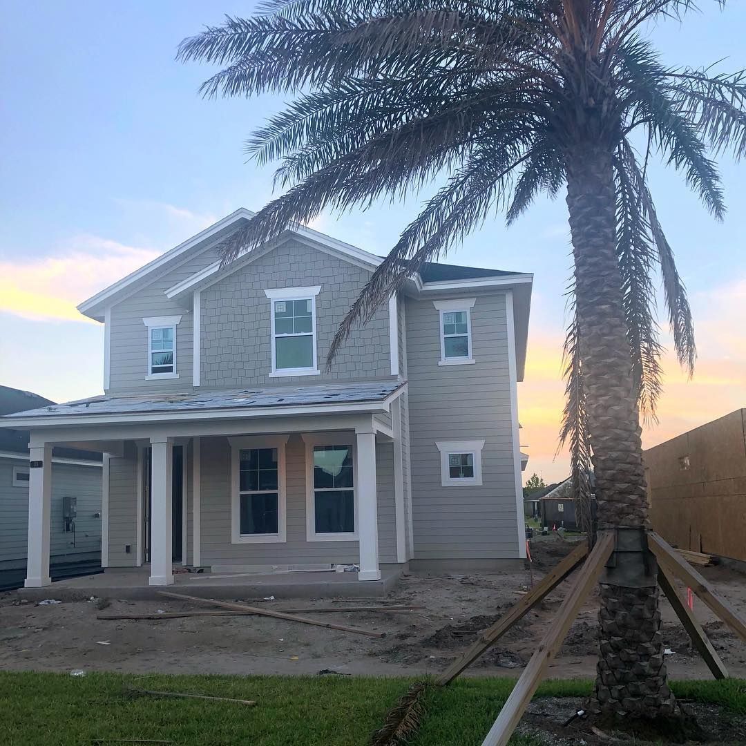A house under construction with a palm tree in front of it.