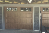 Wood garage doors with square windows on the top.
