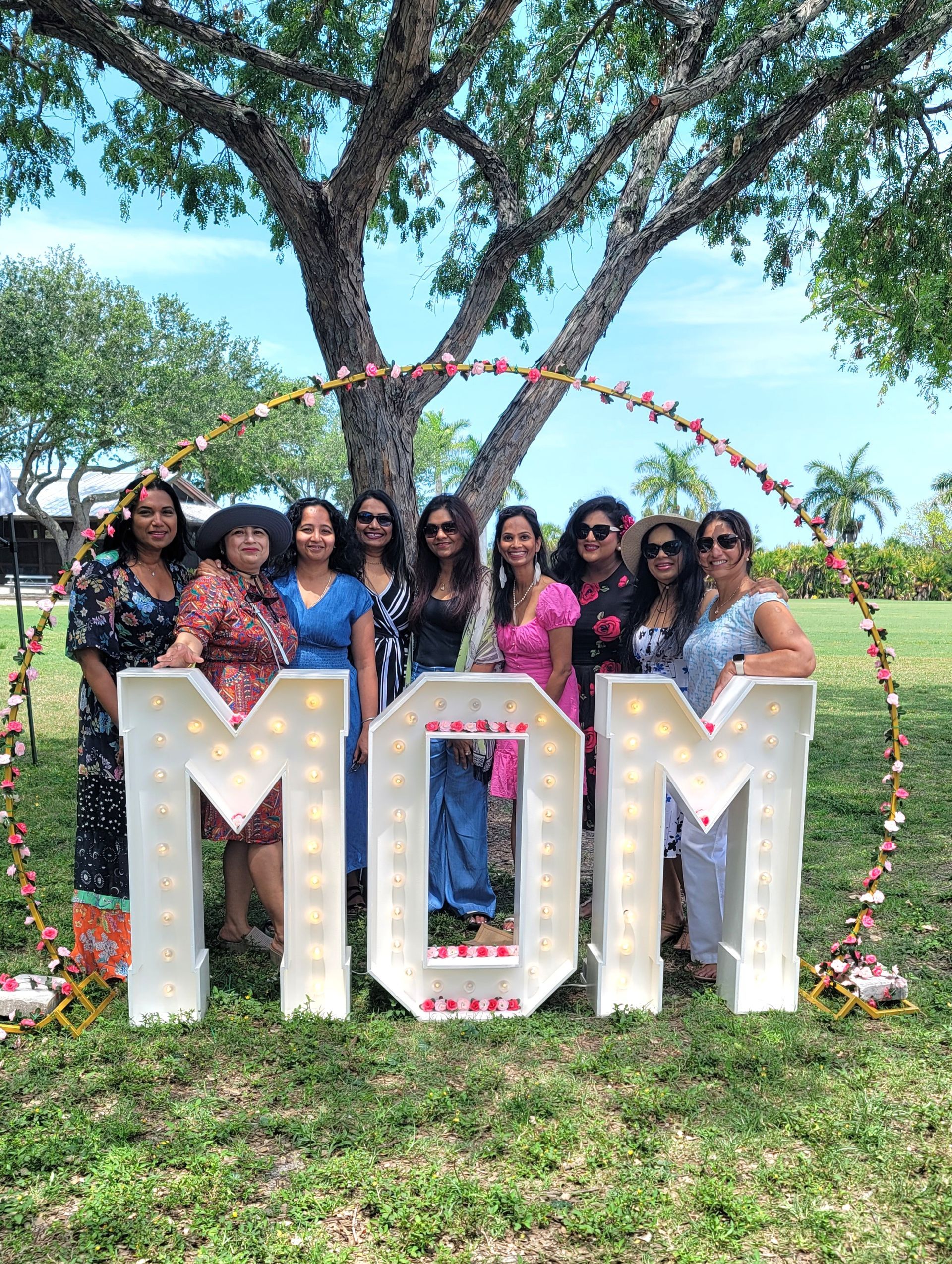 Group of women pose behind lit-up 