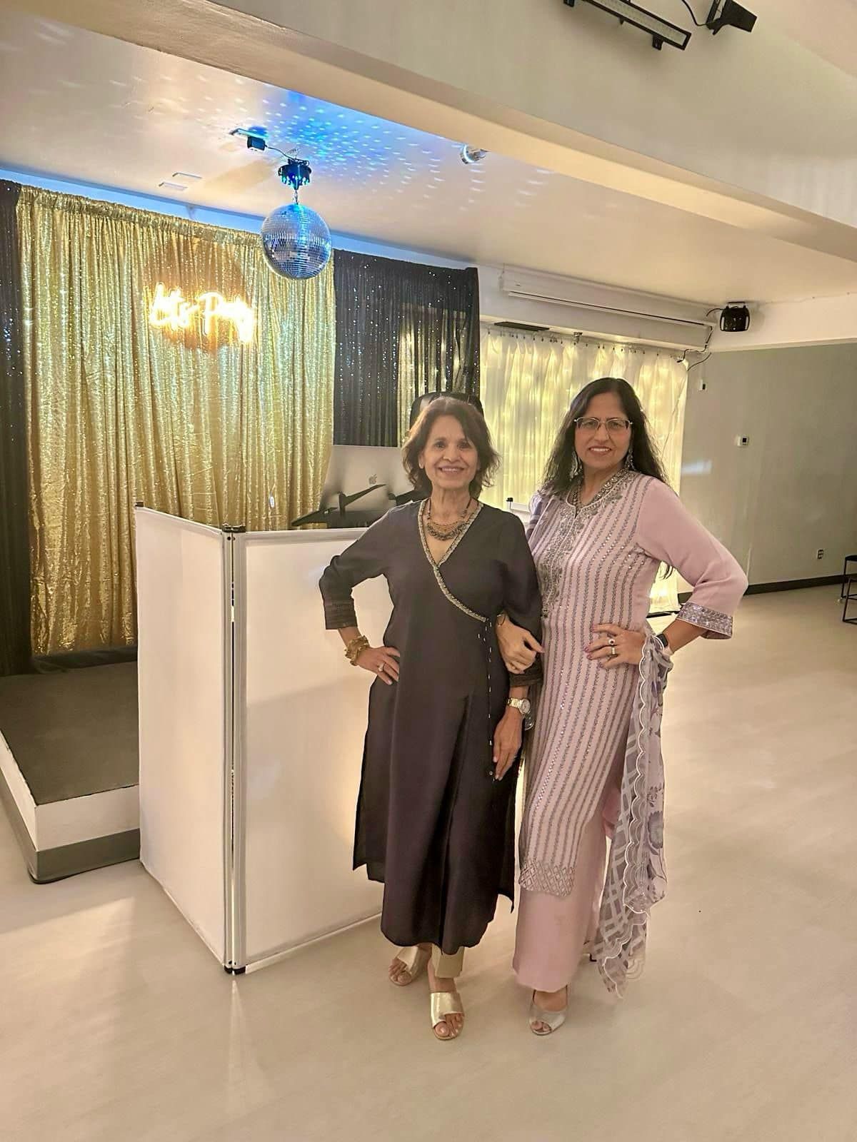 Two women are standing next to each other in a room.