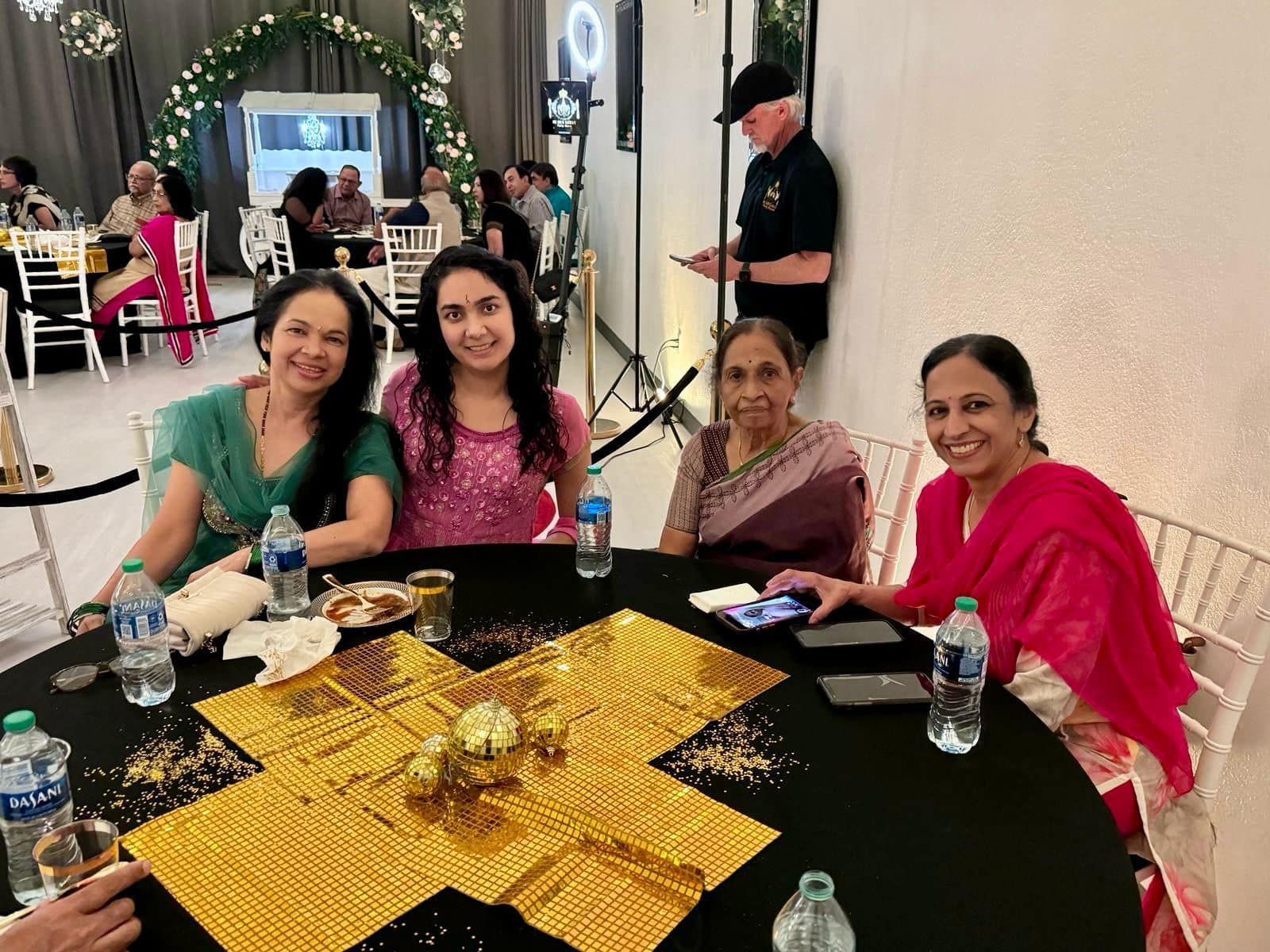 A group of women are sitting around a table at a party.