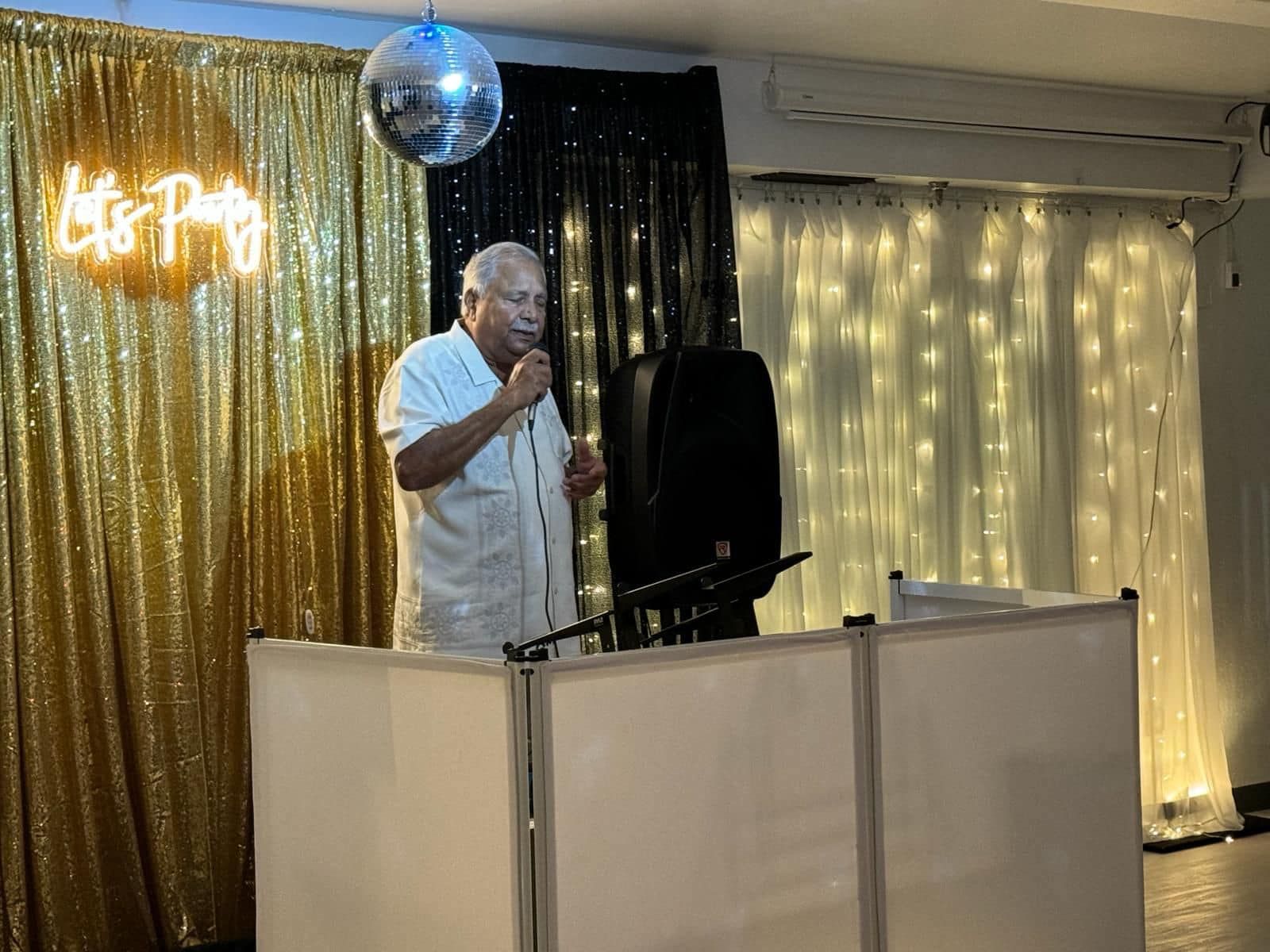 A man is standing in front of a microphone in a room.