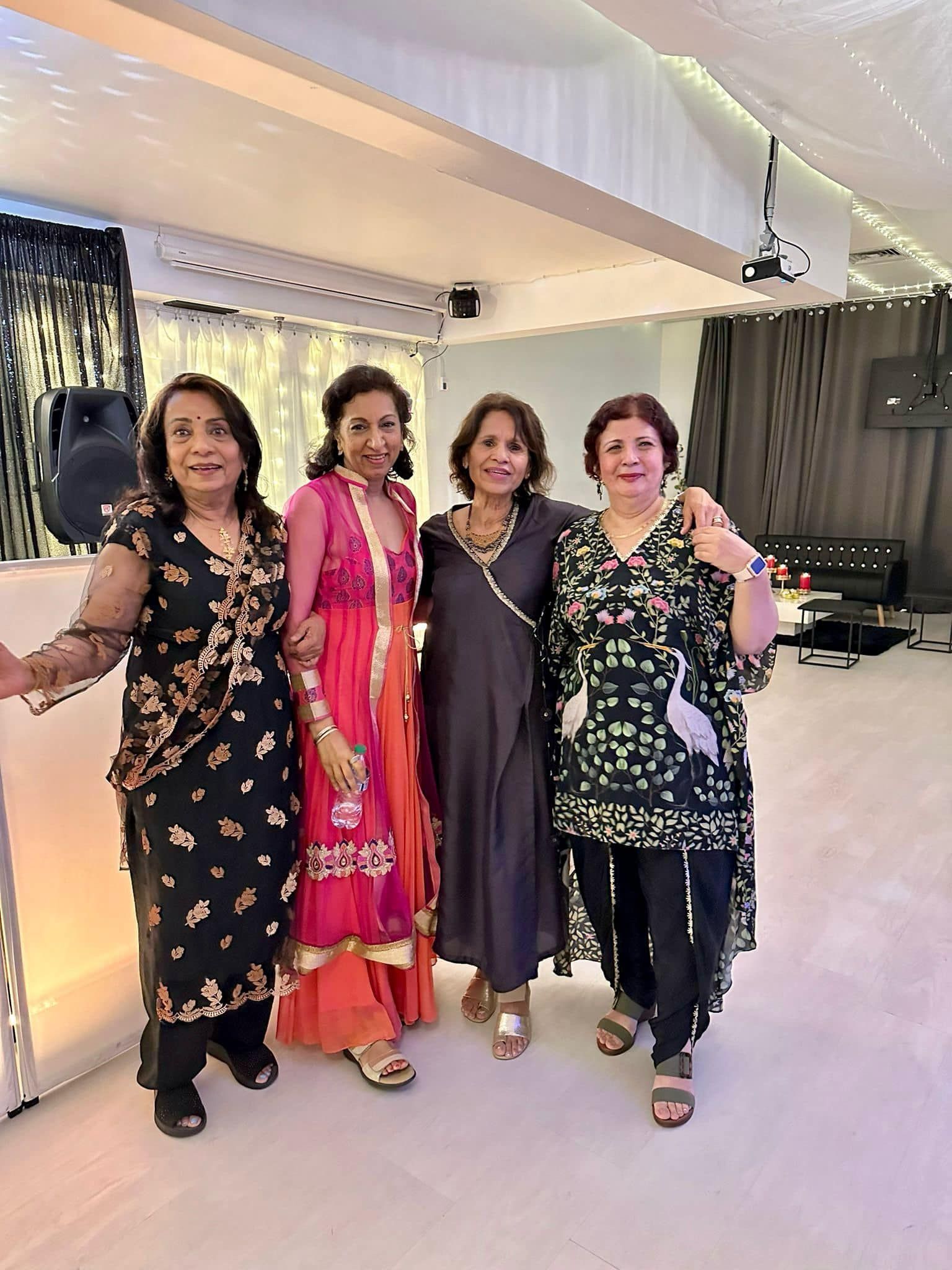 A group of women are posing for a picture together in a room.