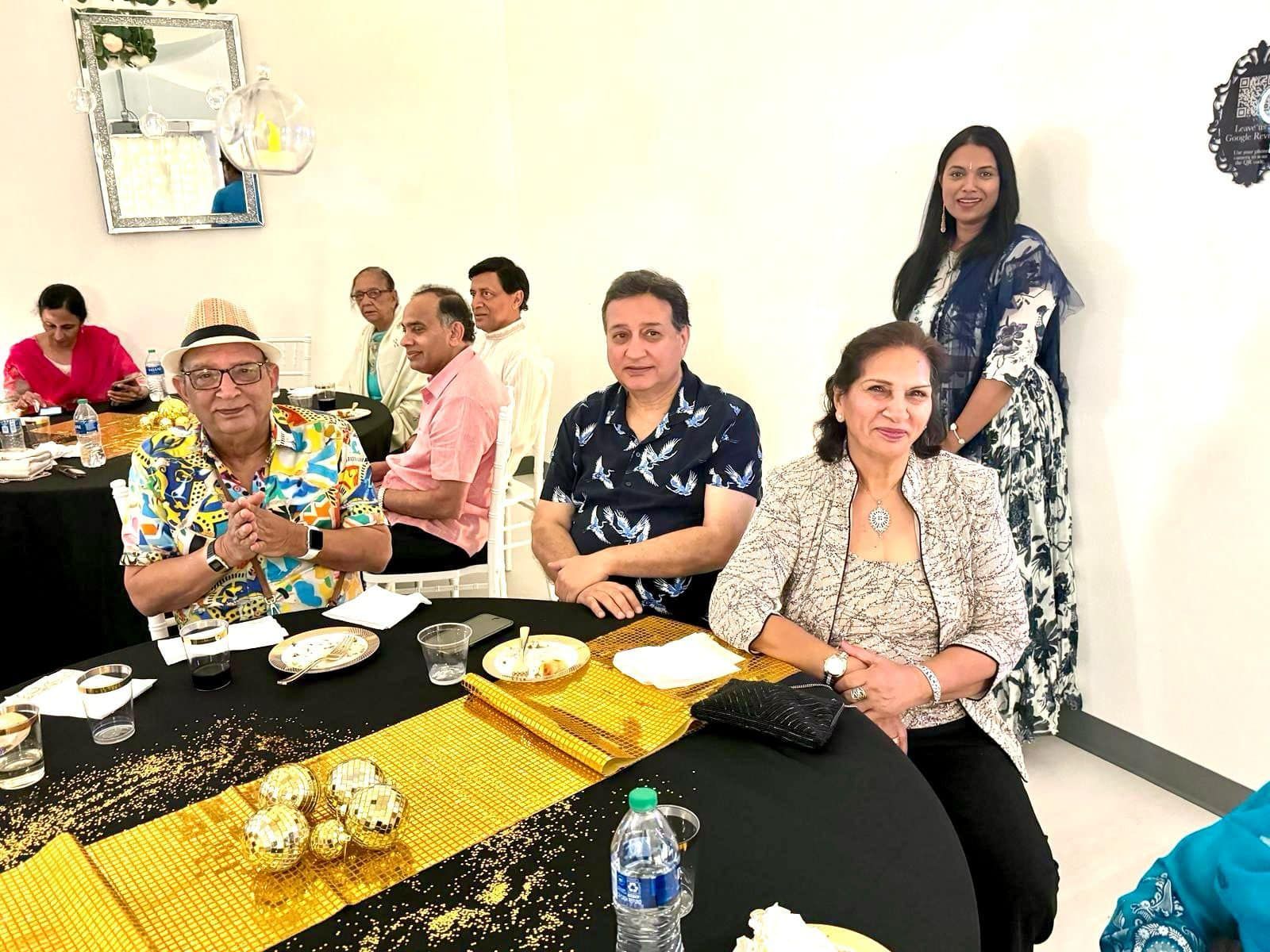 A group of people are sitting at a table with plates of food.