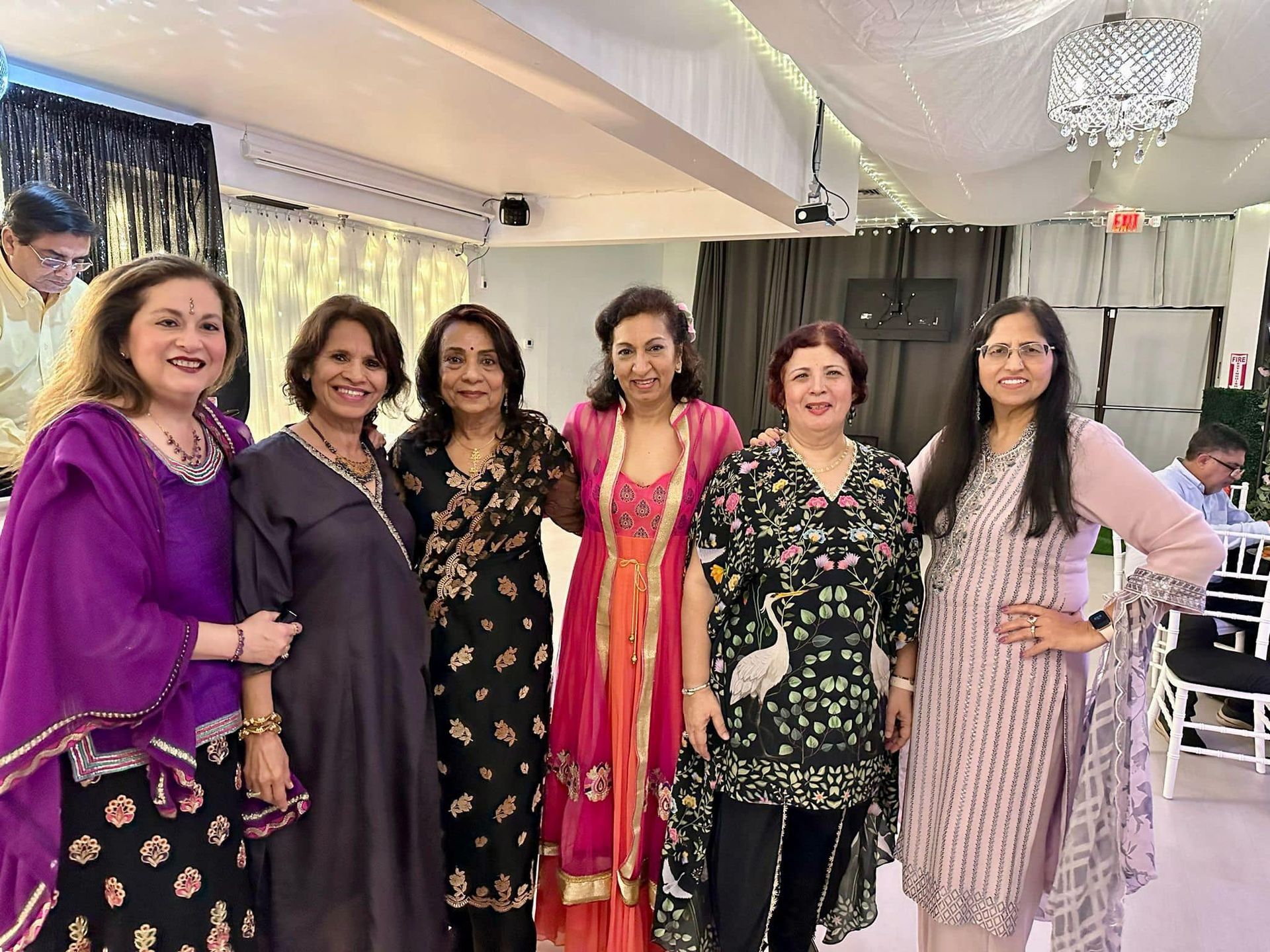 A group of women are posing for a picture together in a room.