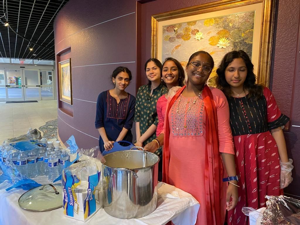 A group of women are standing next to each other in front of a table.