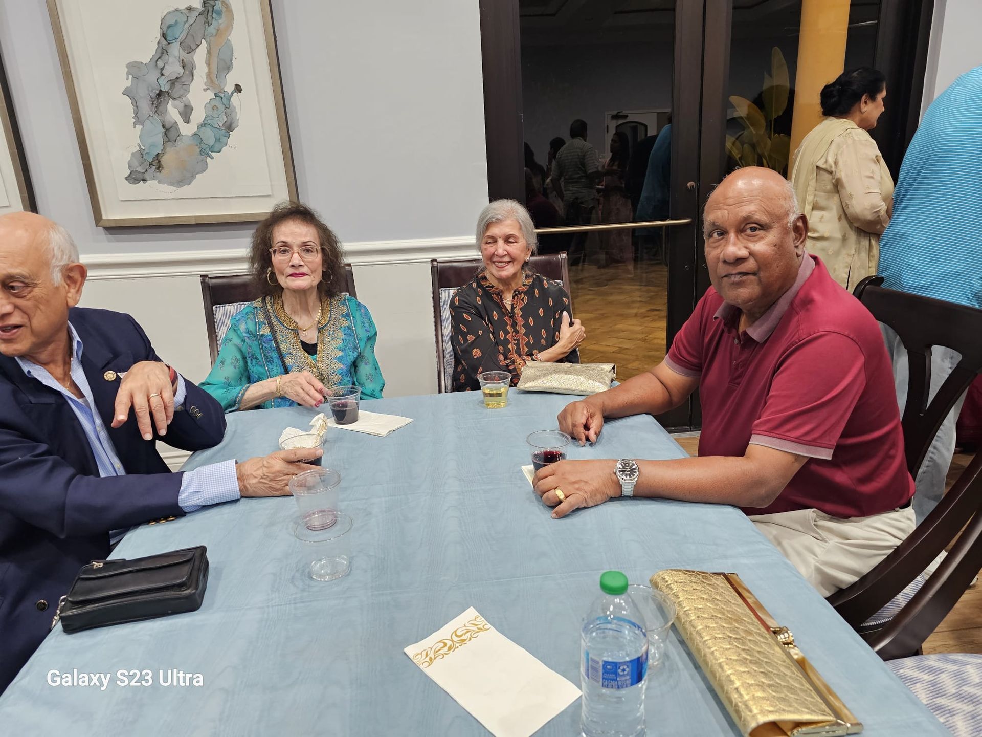 A group of people are sitting around a table drinking wine.