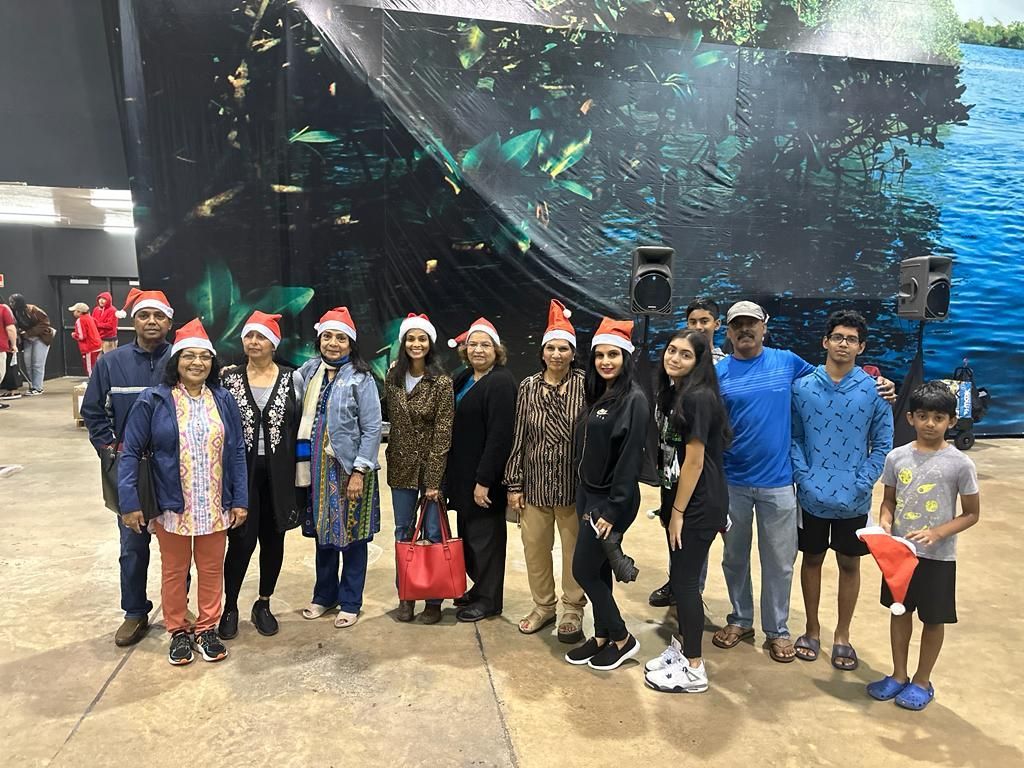 A group of people wearing santa hats are posing for a picture.