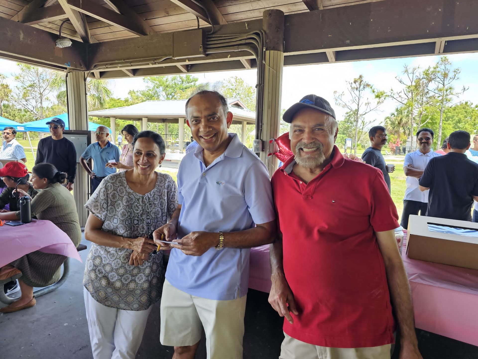 A group of people are posing for a picture in a pavilion.