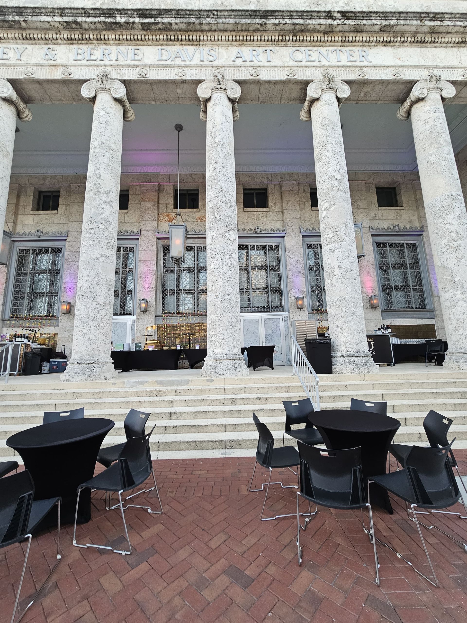 Exterior view with stone columns and outdoor seating, possibly a reception.