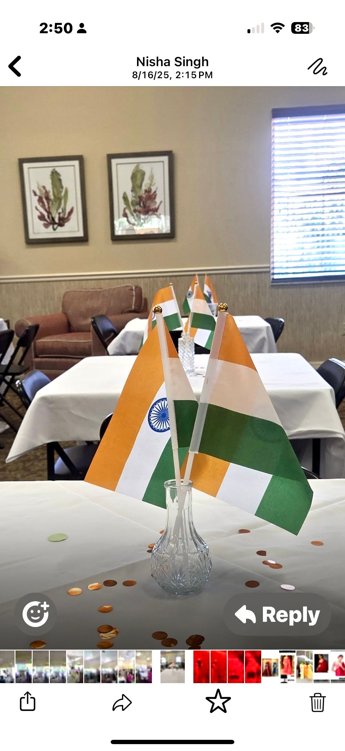 Indian flags in a vase on a white tablecloth, with gold confetti. Indoors, with tables and chairs.