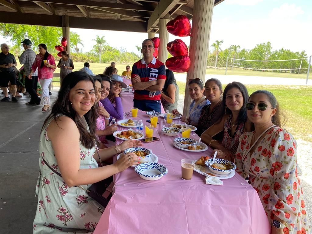 A group of people are sitting at a table with plates of food.