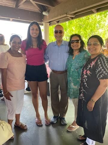 A group of people are posing for a picture under a canopy.