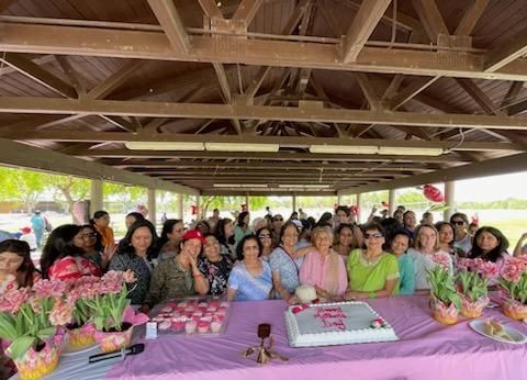 A group of people are sitting at a table with a cake.