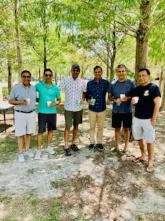 A group of men are standing next to each other in a park.