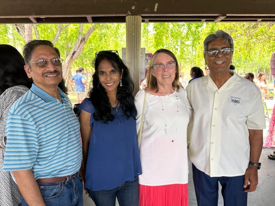 A group of people are posing for a picture in a park.