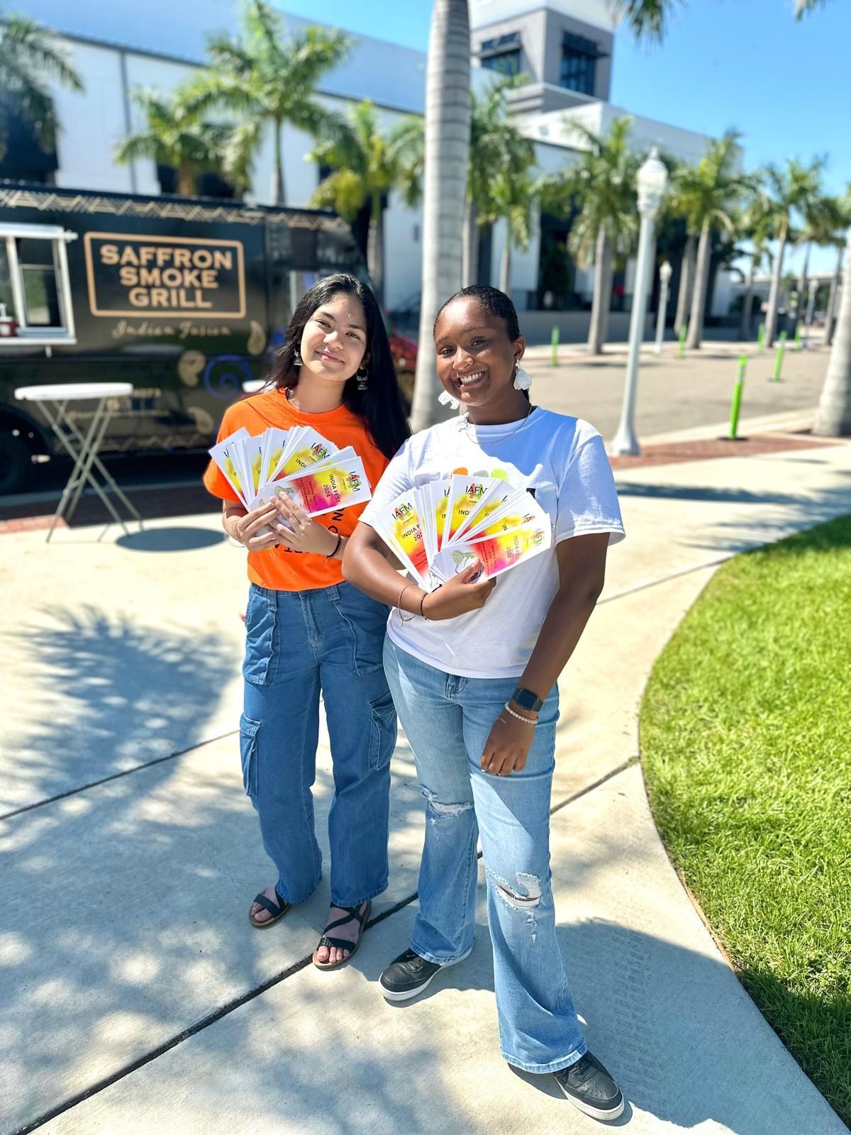 Two women holding brochures next to the 