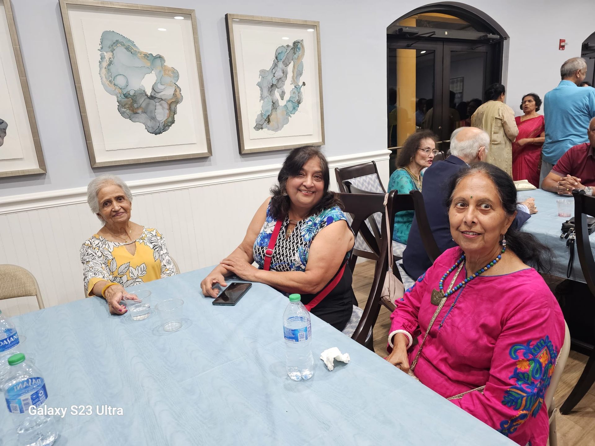 A group of women are sitting at a table in a room.