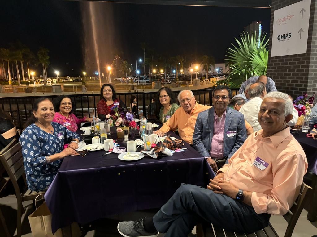 A group of people are sitting at a table with plates of food.