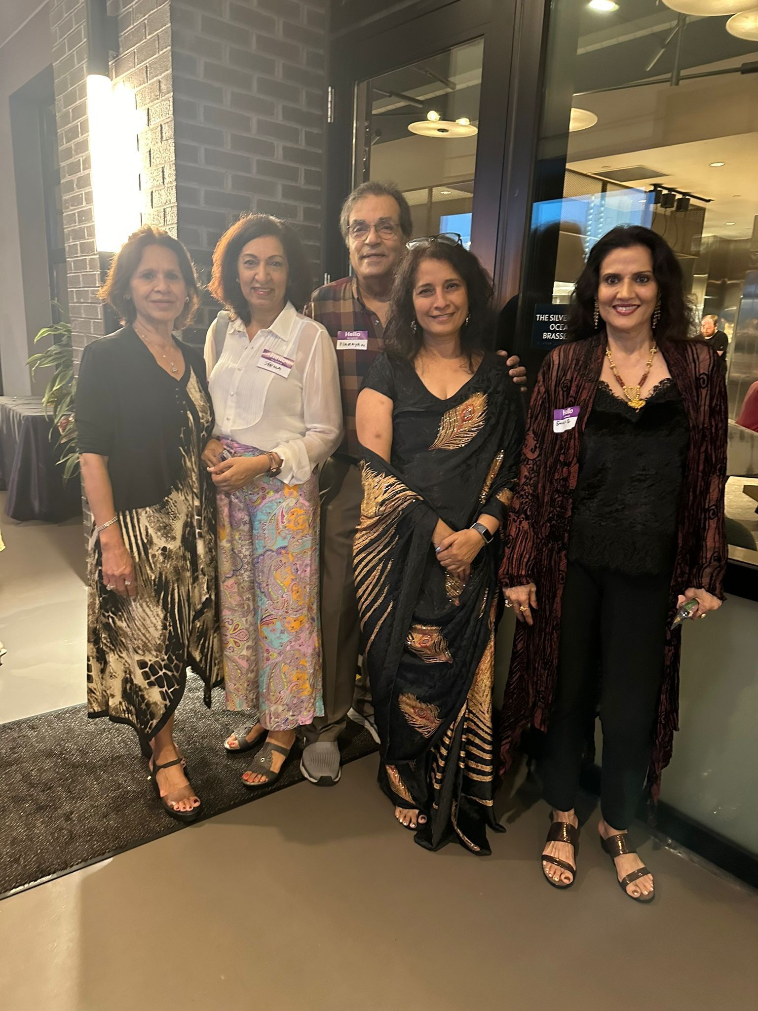 A group of women and a man are posing for a picture.