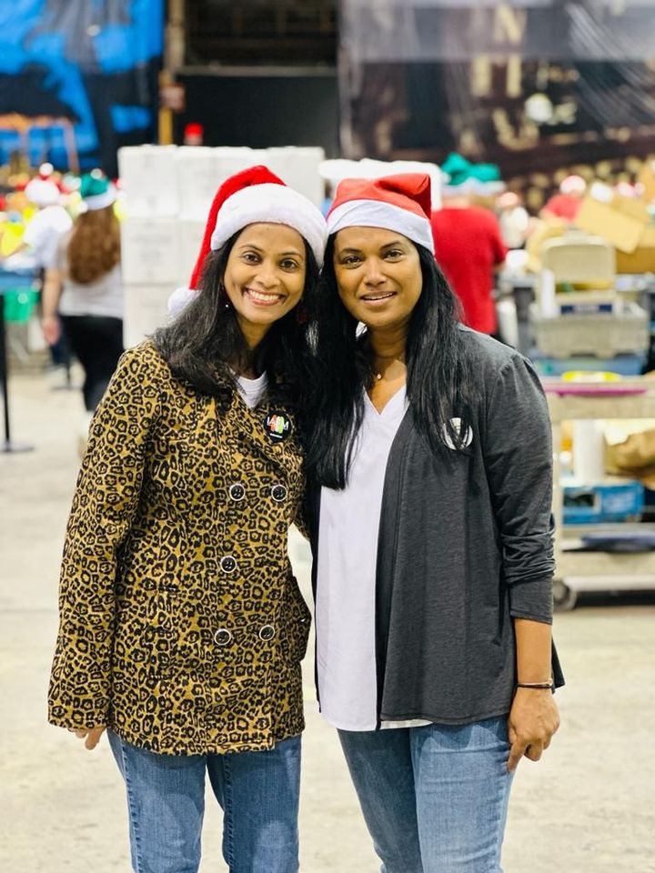 Two women wearing santa hats are posing for a picture.