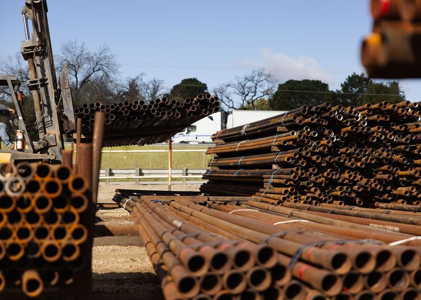 Stacks of rusted metal pipes outdoors at a construction or industrial site