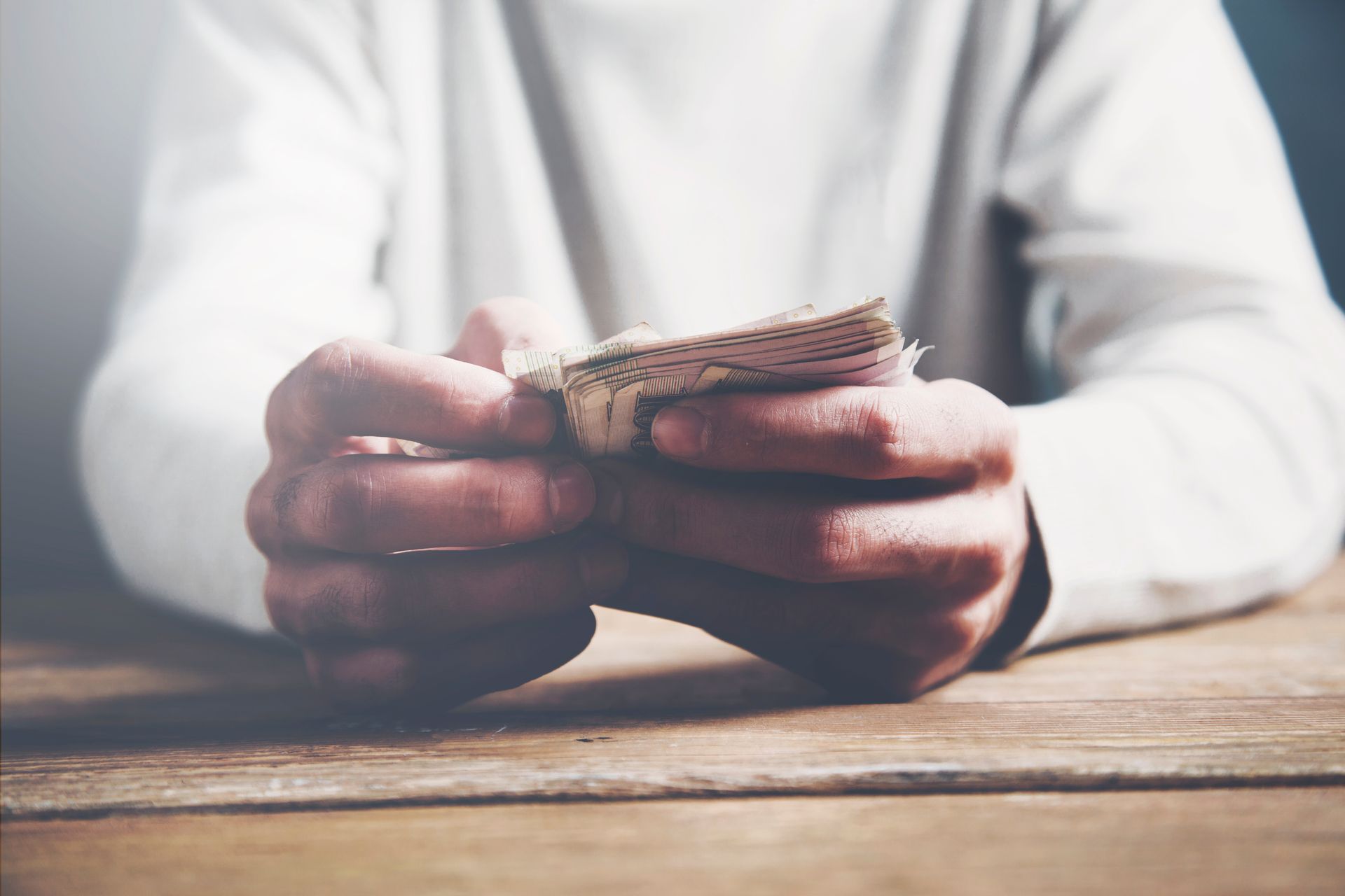 A person is holding a piece of bread in their hands.