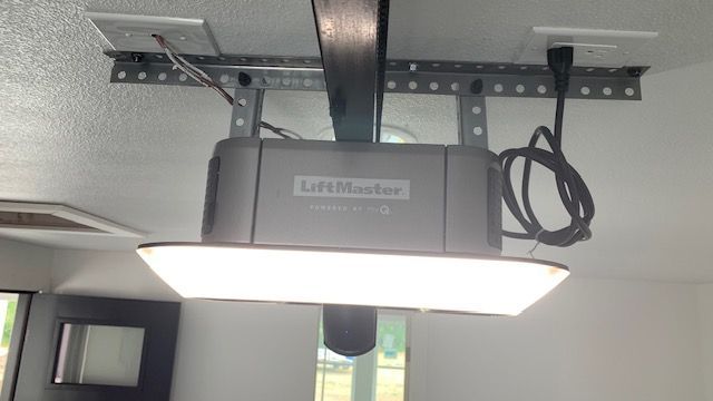 A garage door opener is hanging from the ceiling in a room.
