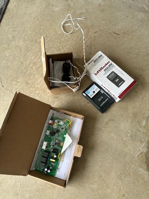 Two boxes of parts for a garage door opener are sitting on the floor.