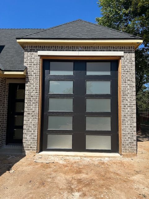 A brick house with a black garage door